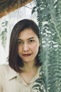 Mekanı süsleyen eğrelti otlarıyla ayakta duran kadınlar