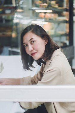 Bir kafede aynanın yanında oturan bir kadın.