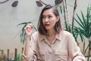 Arka bahçede ahşap bir sandalyede oturan kadın