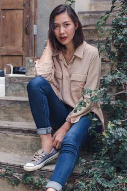 Kadın zevkle eski merdivende oturdu.