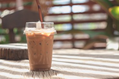 Ahşap bir masaya yerleştirilen plastik bir kupa soğuk kakao