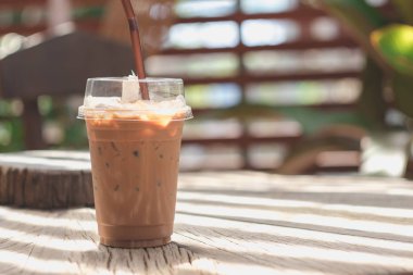 Ahşap bir masaya yerleştirilen plastik bir kupa soğuk kakao