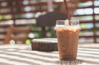 Ahşap bir masaya yerleştirilen plastik bir kupa soğuk kakao