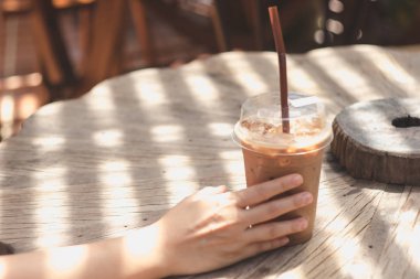 Ahşap bir masaya yerleştirilen plastik bir kupa soğuk kakao