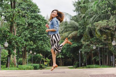 Uzun etek giyen bir kadın yerden atlıyor.