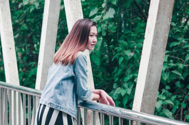 Parkta köprüye yaslanan kadın