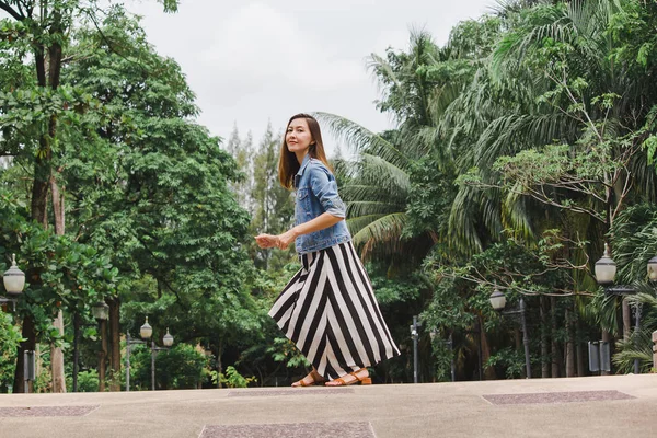 Uzun etek giyen bir kadın yerden atlıyor.