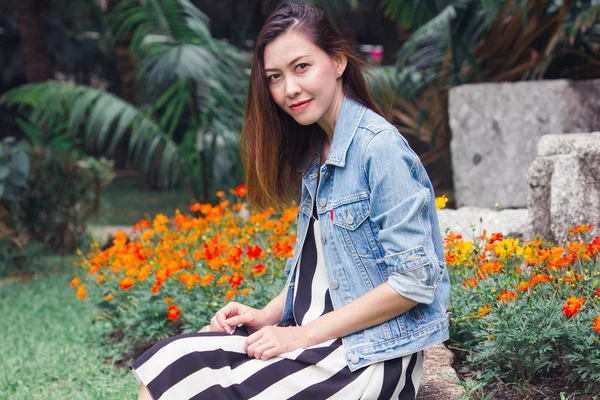 Mujer Sentada Parque Donde Las Flores Florecen Bellamente —  Fotos de Stock