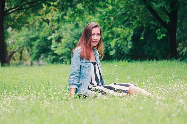 芝生に座っている長い髪の女性 — ストック写真