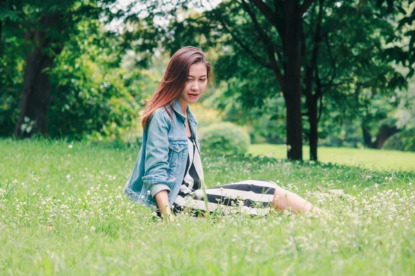 Eine Langhaarige Frau Sitzt Auf Dem Rasen — Stockfoto
