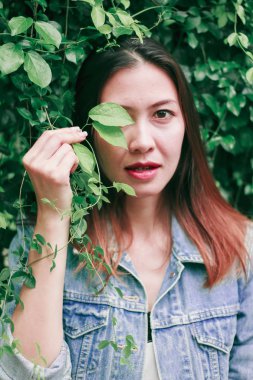 Ağaç duvarın karşısında duran uzun saçlı bir kadın