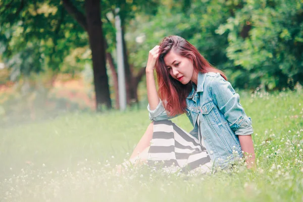 Eine Langhaarige Frau Sitzt Auf Dem Rasen — Stockfoto