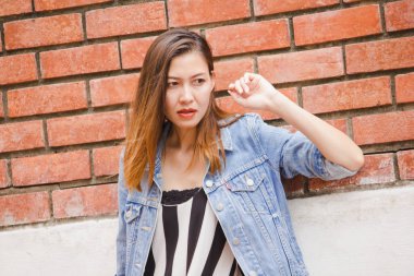 kadın eski bir kırmızı tuğla duvara yaslanmış