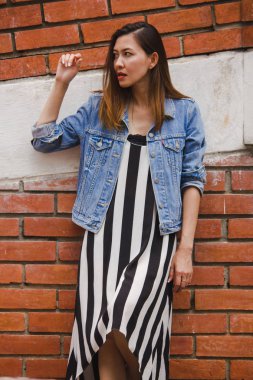 kadın eski bir kırmızı tuğla duvara yaslanmış