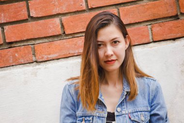 kadın eski bir kırmızı tuğla duvara yaslanmış