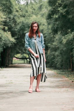 parkta bir bambu ağacının altında duran kadın