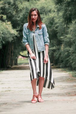 parkta bir bambu ağacının altında duran kadın