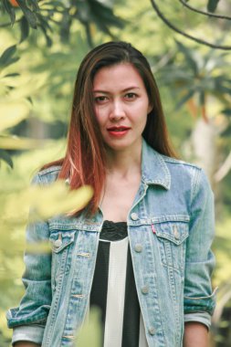 Parkta Bush'un altında duran kadın