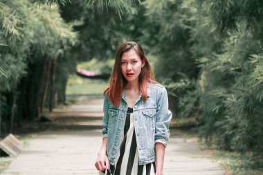 parkta bir bambu ağacının altında duran kadın