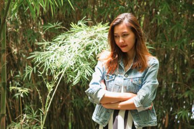 parkta bir bambu ağacının altında duran kadın