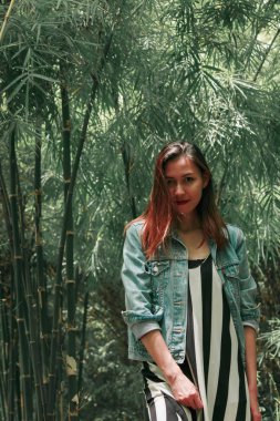 parkta bir bambu ağacının altında duran kadın