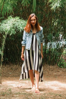 parkta bir bambu ağacının altında duran kadın