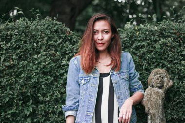 Ağaç duvarın karşısında duran uzun saçlı bir kadın