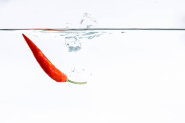 Kırmızı biber, su sıçraması, beyaz arka planda.