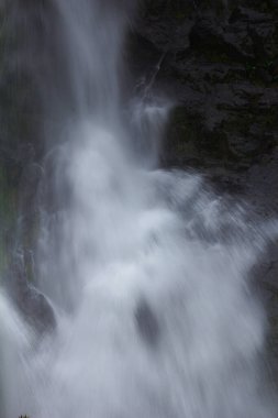 Doğal bir şelale uçurumdan akan bir vadiye doğru uzun bir hat çizer..