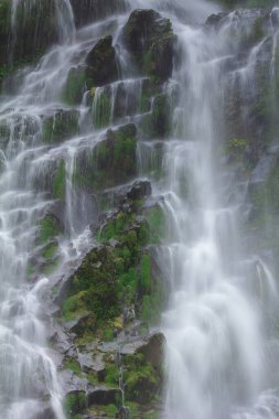 Doğal bir şelale uçurumdan akan bir vadiye doğru uzun bir hat çizer..