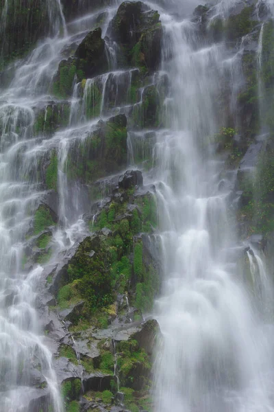 Doğal bir şelale uçurumdan akan bir vadiye doğru uzun bir hat çizer..