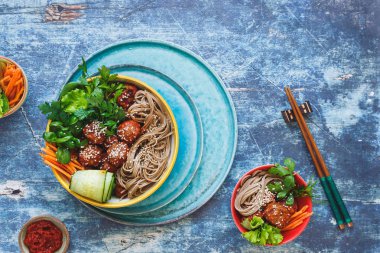 Buğday soba noodle, taze sebze ve otlar ile Sriracha köfte. Asya salata öğle veya akşam yemeği için. Üstten görünüm, boşluk, rustik arka plan