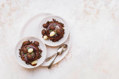Paskalya yuva çikolatalı kek çikolata bukleler ve plaka üzerinde yumurta ile dekore edilmiştir. Ana sayfa görünümü, boşluk, dokulu yüzeyi