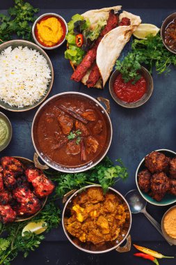 Rogan Josh, tavuk tikka masala, tandır tavuk kanatları ve kebaplar, pirinç ve naan ekmek, üst görünümü ile featuring çeşitli Hint yemekleri