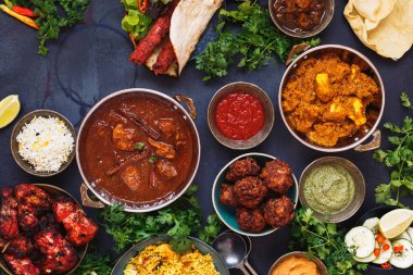 Hindistan'ın tadı. Tavuk tikka masala, rogan josh, kebaplar, tandır tavuk kanatları, hamur işlerinden, dips ve naan ekmeği ile poppadoms içeren gıda çeşitli kase hint gıda bir seçim