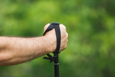 Bir yürüyüş direğini tutan el. Elinde tanınmayan bir yürüyüş direği tutan adamın eli. Seçici odak, boşluğu kopyala