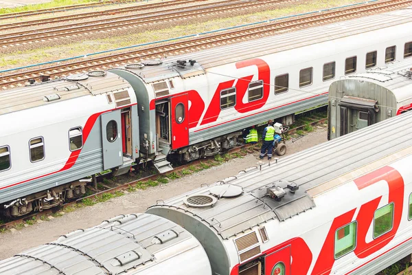 Railway workers repair a railway car. Passenger wagon is under r