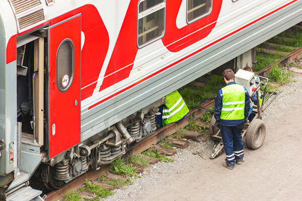Railway workers repair a railway car. Passenger wagon is under r