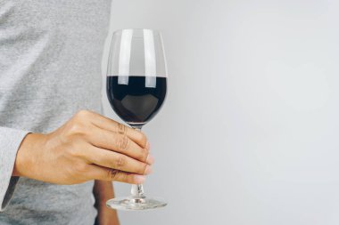 elinde bir bardak kırmızı şarap, beyaz arka plan gri tişörtlü adam