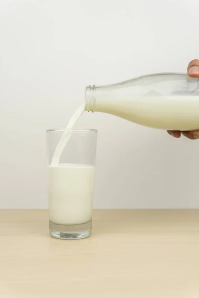 ボトルからグラスに注いでミルクを手します — ストック写真