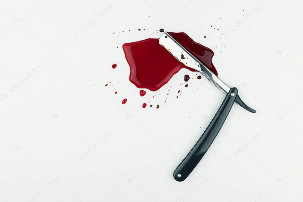 crime scene concept, a bloody vintage straight razor on white background