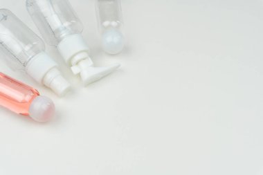 taşınabilir bir pembe sıvı plastik şişe ve beyaz arka plan üzerinde üç boş sıvı kapları yakın çekim