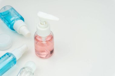 pembe, mavi ve net sıvı kapları beyaz arka plan üzerinde beyaz bir taşınabilir krem kavanoz ile yakın çekim