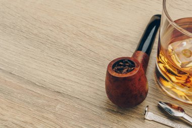 Tütün, bir boru dış müdahale aracı ve bir bardak viski ahşap masa üzerinde yasaktır borunun yakın çekim