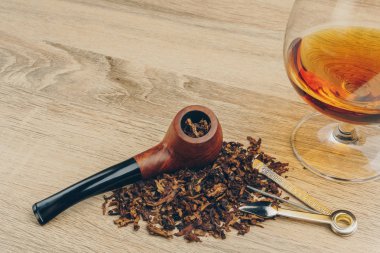 Tütün, bir boru dış müdahale aracı ve bir bardak brendi ahşap masa üzerinde yasaktır borunun yakın çekim