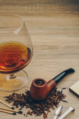 Tütün, bir boru dış müdahale aracı, maçlar ve bir bardak brendi ahşap masa üzerinde yasaktır borunun yakın çekim