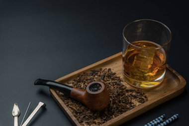 Tütün ve bir bardak viski ahşap tepsi, bir dış müdahale aracı ve tüp temizleyicileri siyah masada yasaktır boru