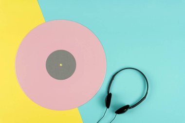 sarı ve mavi arka plan üzerinde siyah bir kulaklık ile pembe uzun yürütme vinil kaydetme veya Lp üstten görünüm