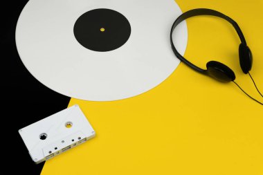 beyaz uzun sarı ve siyah arka plan üzerinde siyah bir kulaklık ve beyaz ses Kaset vinil kayıtla oynamak