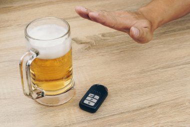 yapmak değil içmek ve götürmek kavramı, bir bardak bira, ahşap masa bulunan bir uzaktan araba anahtarı reddeden adam